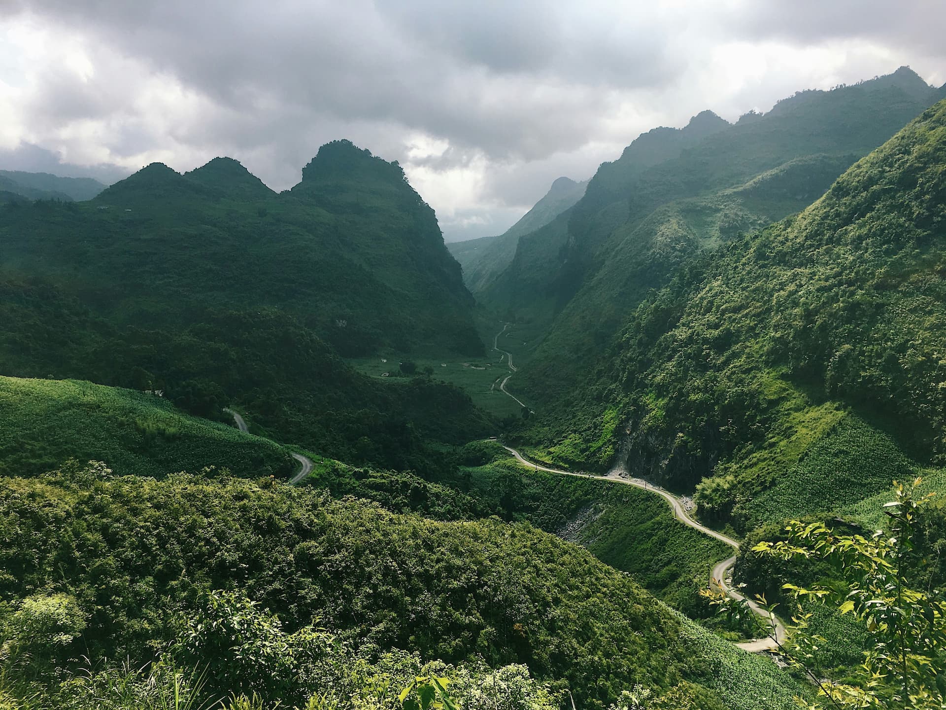 Winding mountain road through a green Vietnamese pass