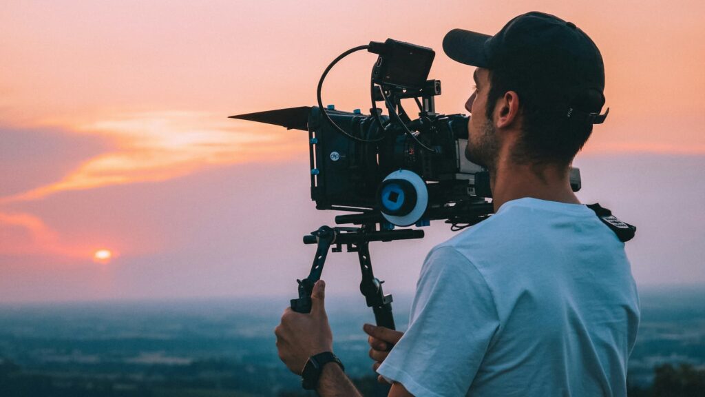Videographer filming sunset landscape